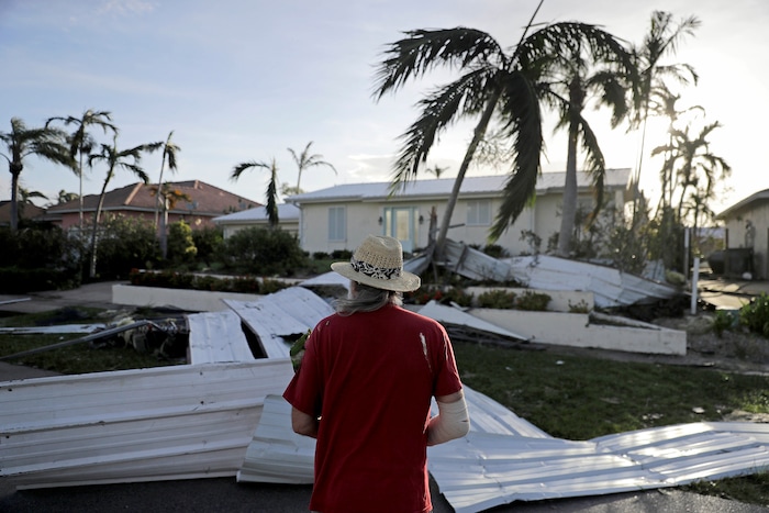 A roof is strewn across a home's lawn as Rick Freedman checks his neighbor's damage from Hurricane Irma in Marco Island, Fla., Monday, Sept. 11, 2017. (AP Photo/David Goldman)