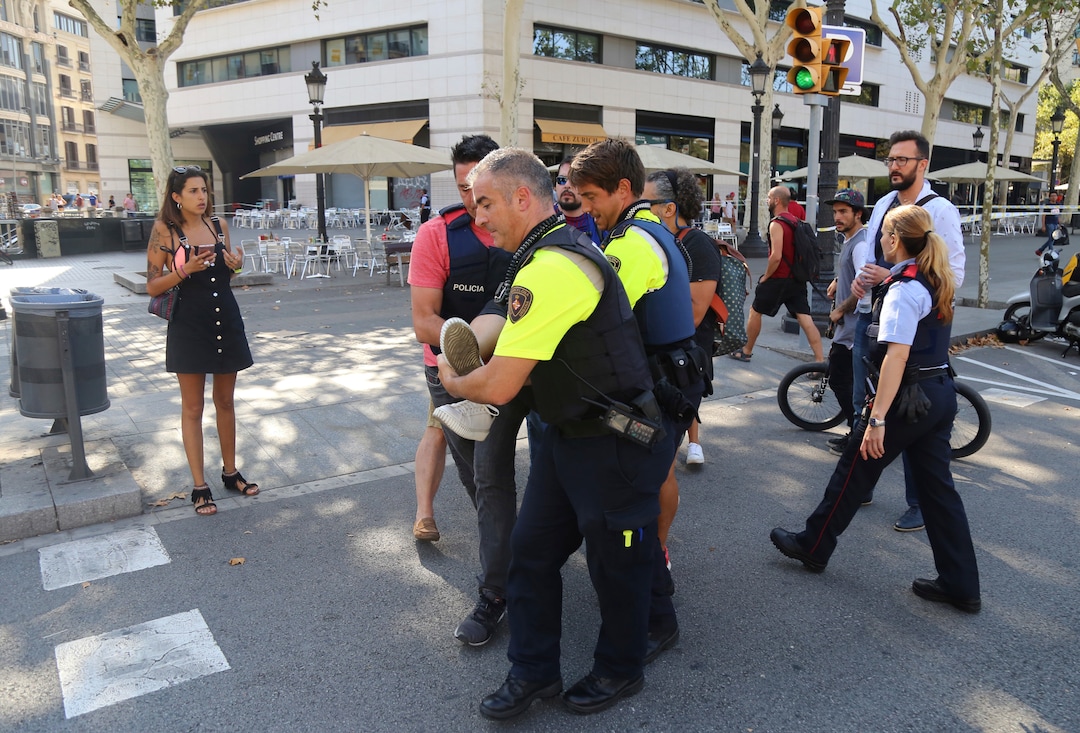 (Oriol Duran | The Associated Press) A person is carried in Barcelona, Spain, Thursday, Aug. 17, 2017 after a white van jumped the sidewalk in the historic Las Ramblas district, crashing into a summer crowd of residents and tourists and injuring several people, police said.