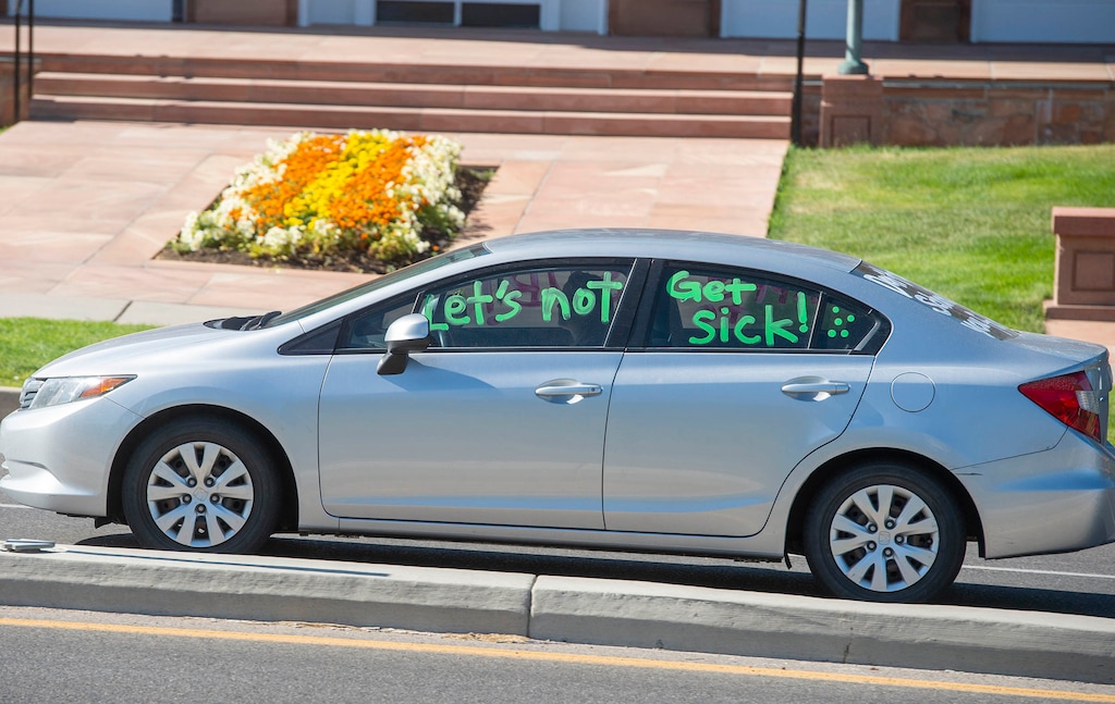 (Rick Egan | The Salt Lake Tribune file photo) A motorist drives a car with a message past the state Capitol during a July 23, 2020, protest to demand state and local leaders ensure Utah schools protect students and staff when schools reopen.