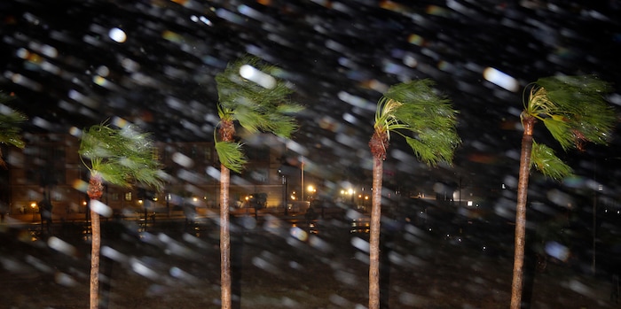 (Eric Gay | The Associated Press) Rain is blown past palm trees as Hurricane Harvey makes landfall, Friday, Aug. 25, 2017, in Corpus Christi, Texas. Harvey intensified into a hurricane Thursday and steered for the Texas coast with the potential for up to 3 feet of rain, 125 mph winds and 12-foot storm surges in what could be the fiercest hurricane to hit the United States in almost a dozen years.