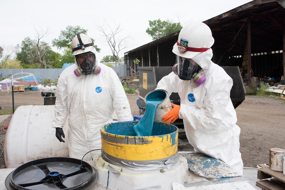 (Briana Scroggins  |  The Utah Investigative Journalism Project) EPA Contractors Maile Lutui and Jaden Lemons shake paint cans before pouring them into containers near the Swift building in Ogden on Thursday, May 16, 2019. The EPA started site clean up on April 1 and plan to finish by August 2019.