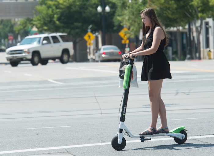(Rick Egan  |  The Salt Lake Tribune)    Ana Salyards, from Helena Montana, rides a Lime Scooter in downtown Salt Lake City, Monday, July 30, 2018.

 