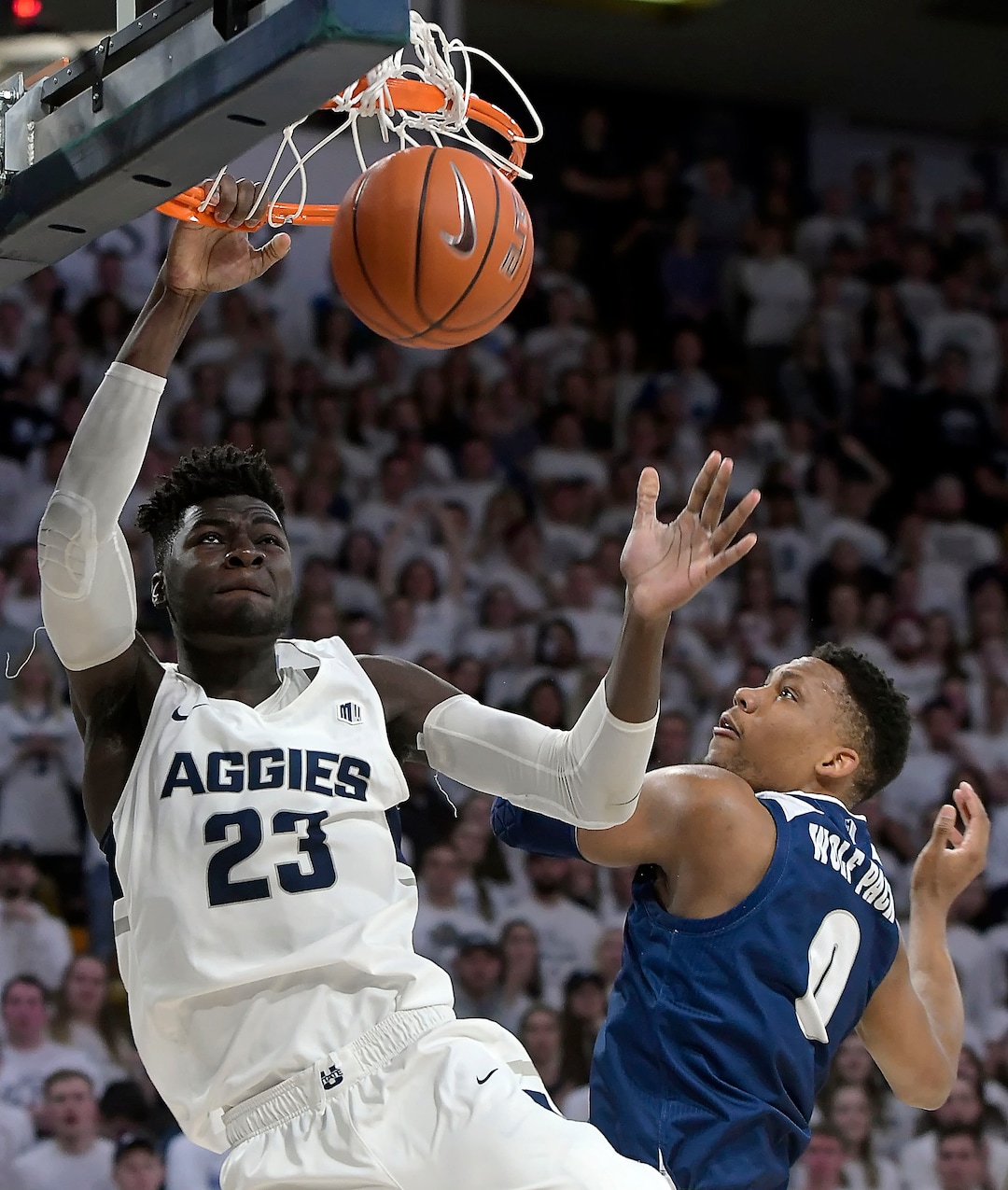 (Eli Lucero  |  The Herald Journal via AP) Utah State center Neemias Queta (23) dunks the ball as Nevada forward Tre'Shawn Thurman (0) defends during an NCAA college basketball game, Saturday, March 2, 2019, in Logan, Utah.