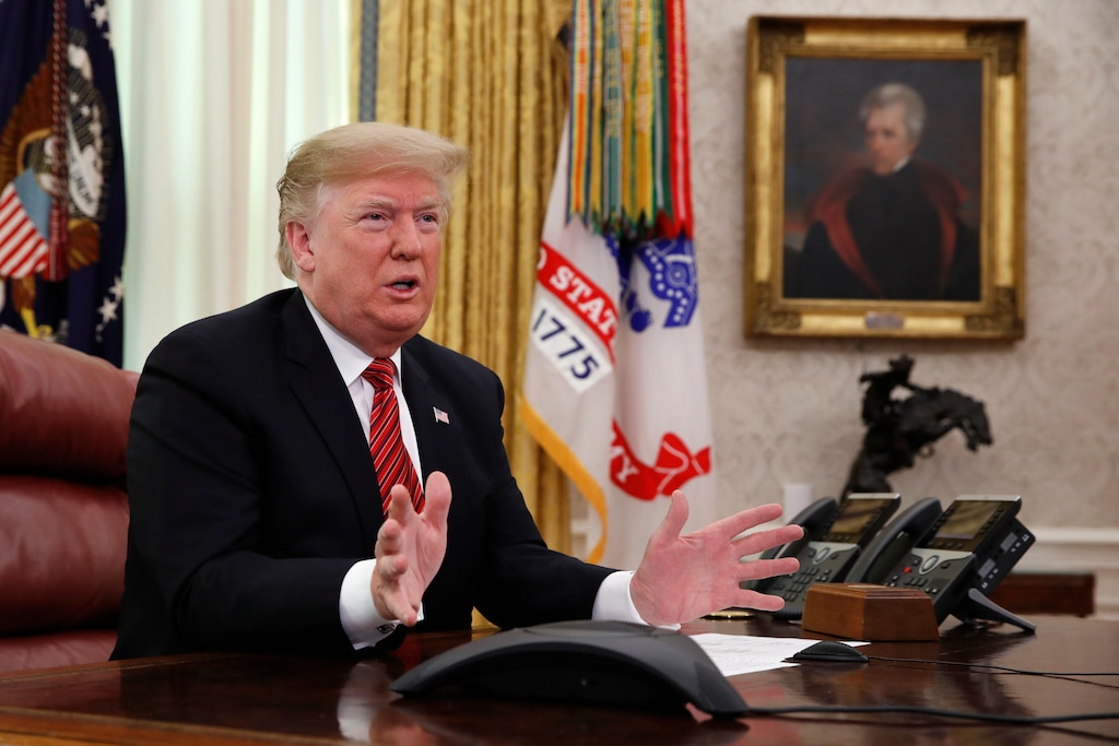 President Donald Trump greets members of the five branches of the military by video conference on Christmas Day, Tuesday, Dec. 25, 2018, in the Oval Office of the White House. The military members were stationed in Guam, Qatar, Alaska, and two groups in Bahrain. (AP Photo/Jacquelyn Martin)
