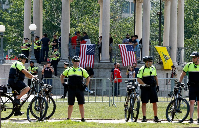 Police stand at a barricade around the bandstand before a planned "Free Speech" rally by conservative activists on Boston Common, Saturday, Aug. 19, 2017, in Boston.  Police Commissioner William Evans said Friday that 500 officers, some in uniform, others undercover, would be deployed to keep the two groups apart. (AP Photo/Michael Dwyer)