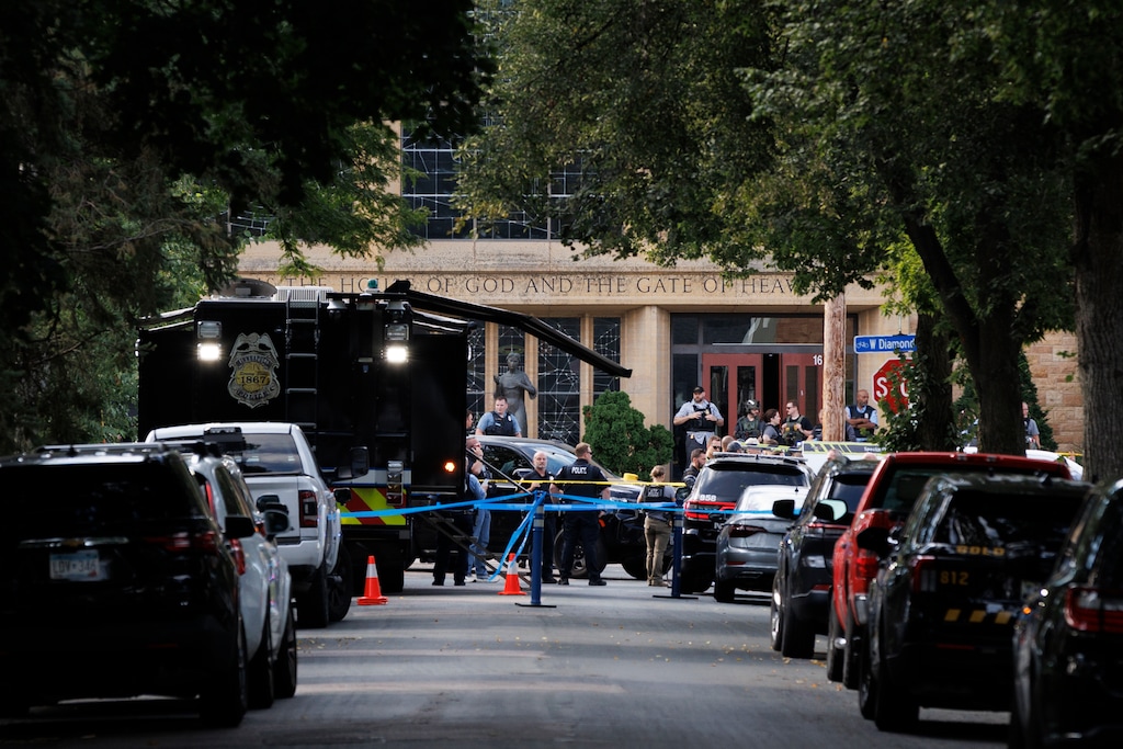 (Liam James Doyle | The New York Times) Members of law enforcement at the scene of a shooting at the Annunciation Catholic Church in Minneapolis, on Wednesday, Aug. 27, 2025.