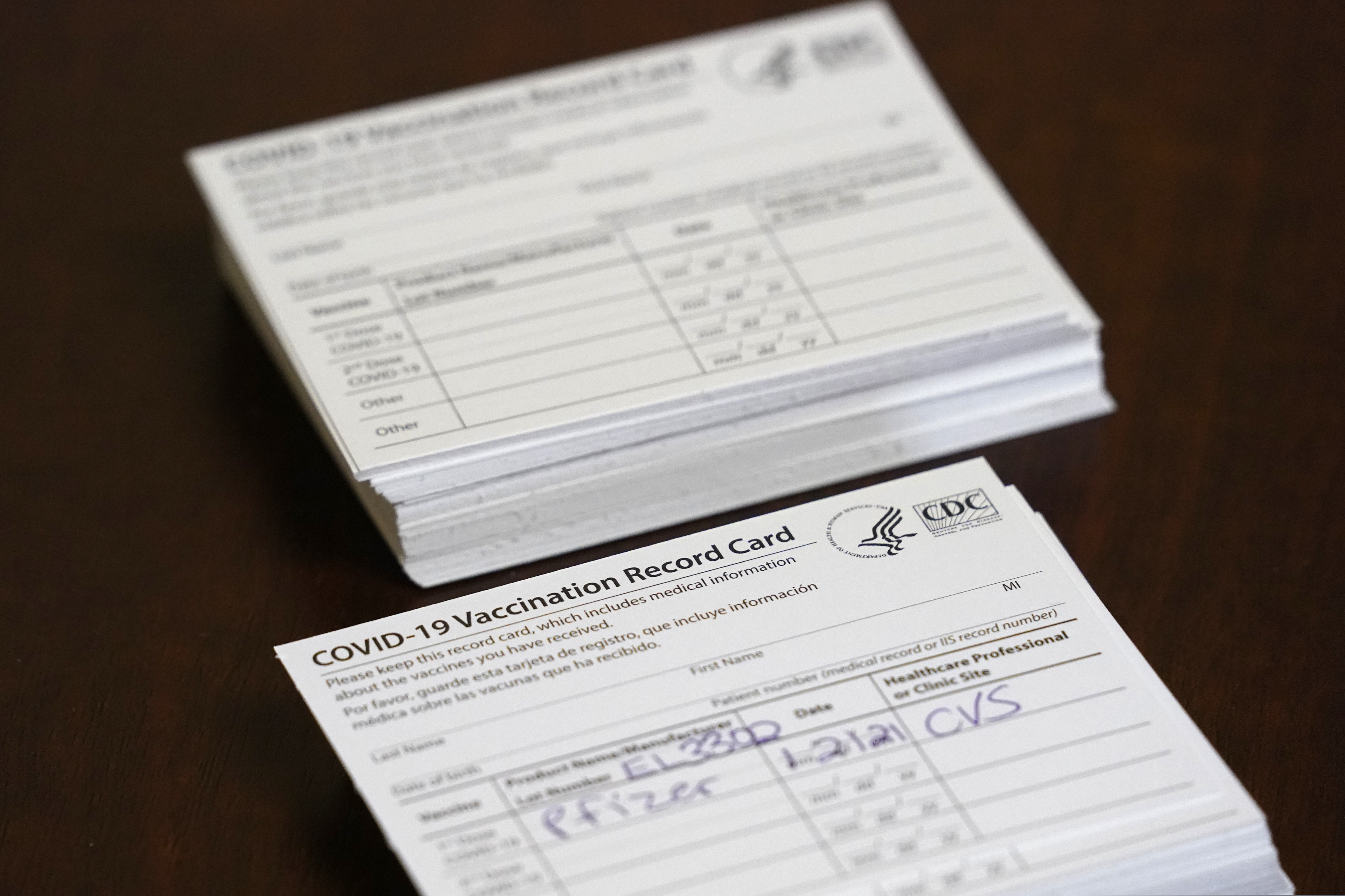(AP Photo/Wilfredo Lee) FILE - Vaccination record cards are shown before residents are inoculated, Thursday, Jan. 21, 2021, at the Isles of Vero Beach assisted and independent senior living community in Vero Beach, Fla. The government tasked CVS and Walgreens with administering the shots to long-term care locations in nearly every state. A Utah pharmacist has admitted he gave COVID-19 vaccination cards to half a dozen people without giving them a shot of the vaccine.