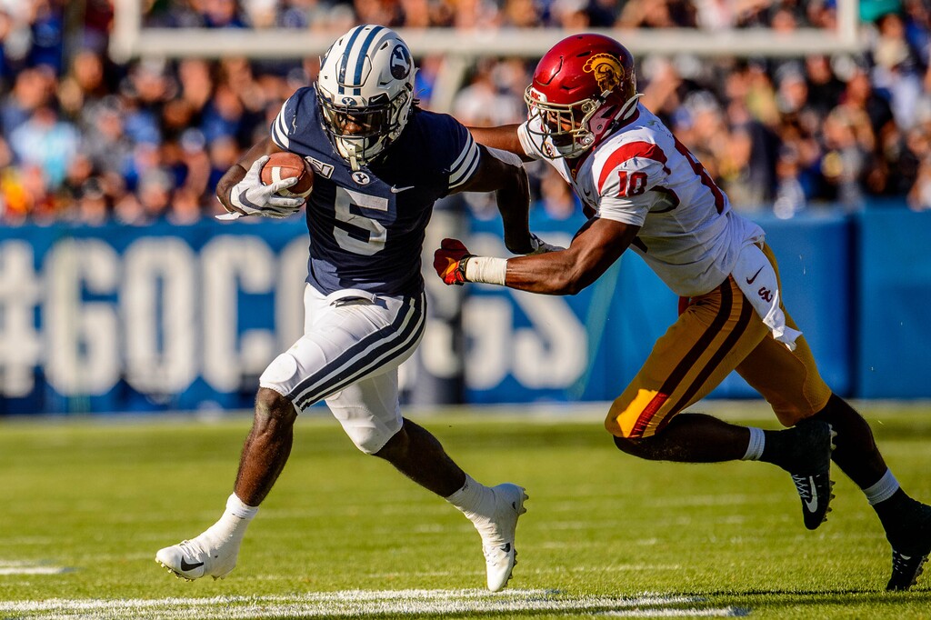 (Trent Nelson  |  The Salt Lake Tribune)  Brigham Young Cougars running back Ty'Son Williams (5) runs the ball, with USC Trojans linebacker John Houston Jr. (10) defending, as BYU hosts USC, NCAA football in Provo on Saturday Sept. 14, 2019.