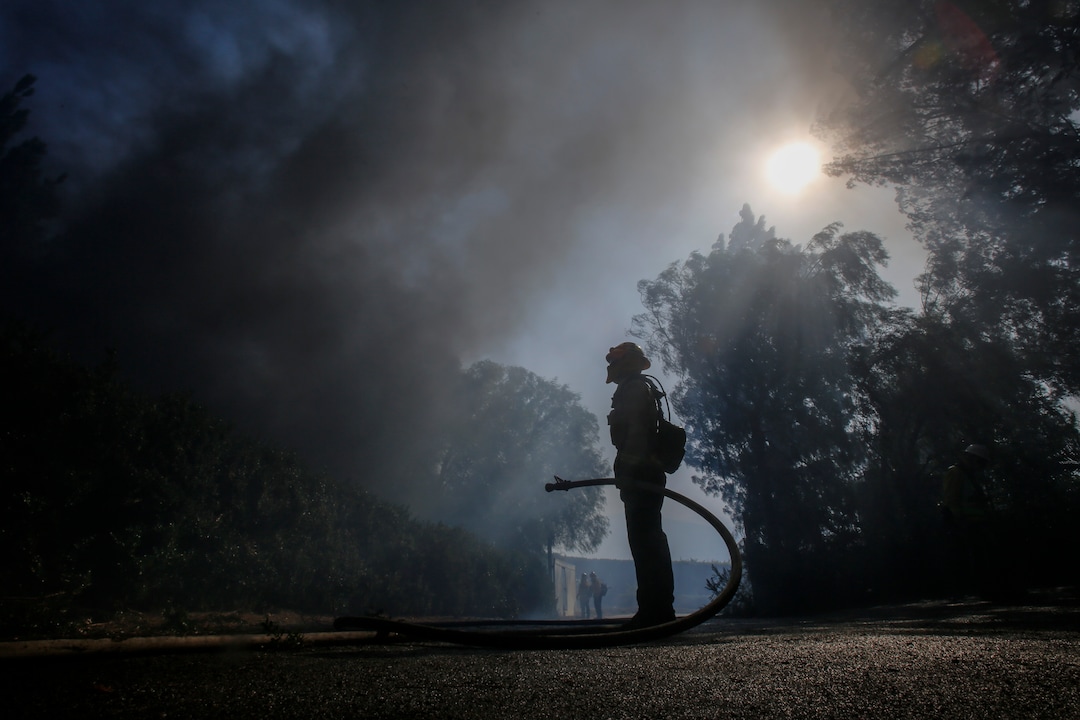 (Ringo H.W. Chiu | AP) Firefighter Brett Reed battles a wildfire near a ranch in Simi Valley, Calif., Wednesday, Oct. 30, 2019.