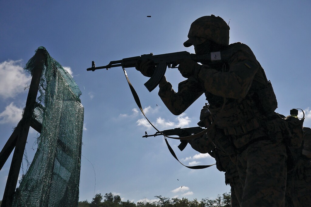 In this photo provided by Ukraine's 65th Mechanized Brigade press service, recruits practice military skills on a training ground in a sunflower field in the Zaporizhzhia region, Ukraine, Monday, Aug. 25, 2025, (Andriy Andriyenko/Ukraine's 65th Mechanized Brigade via AP)