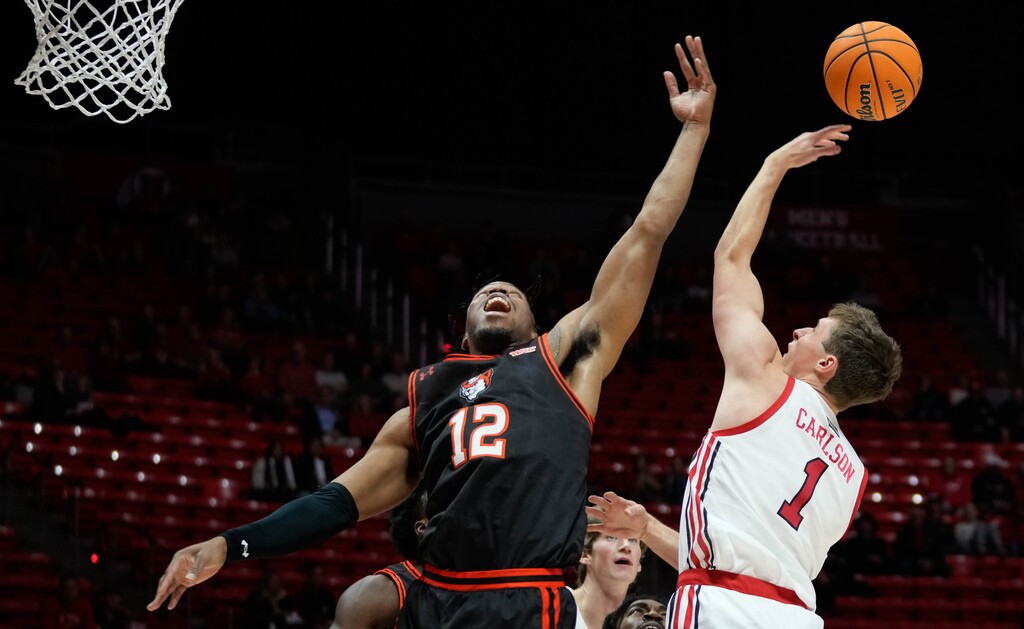 (Francisco Kjolseth | The Salt Lake Tribune) Sam Houston State Bearkats forward Tristan Ikpe (12) blocks Utah Utes forward Ben Carlson (1) as the University of Utah hosts Sam Houston in NCAA basketball in Salt Lake City on Thursday, Nov. 17, 2022.