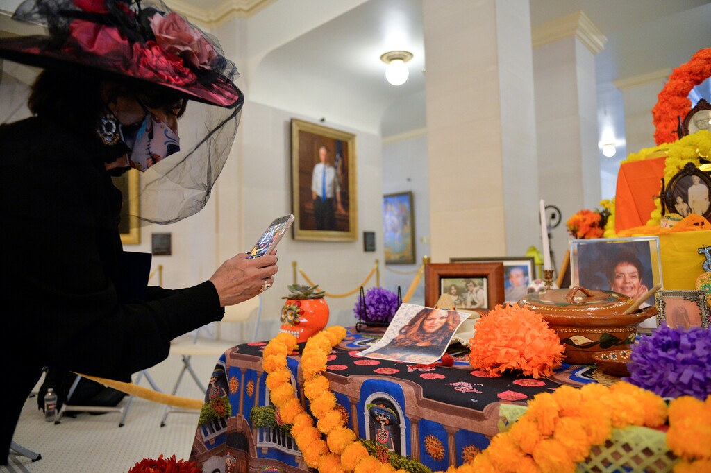 (Chris Samuels | The Salt Lake Tribune) Rocio Mejia, the creator of the altar, takes a photograph at an event commemorating Dia de los Muertos at the Utah Capitol on Monday, Nov. 1, 2021. The event recognized the over 3,200 Utahns who have died from COVID-19.