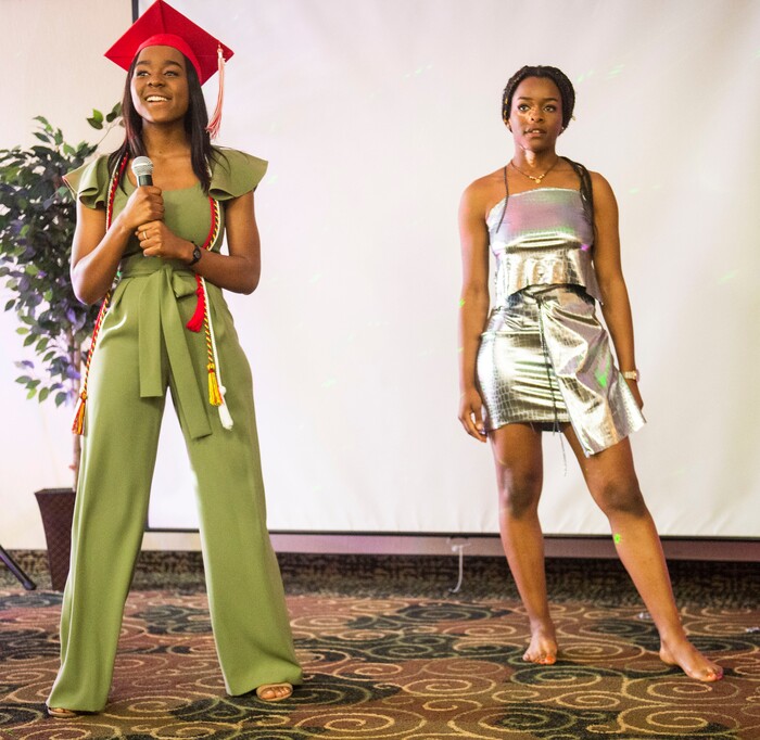 (Rick Egan  |  The Salt Lake Tribune) Academy of Math, Engineering and Science graduate Sylviane Bahati (left) talks about the dress she designed, modeled by her sister Nadine, during a fashion show, graduation celebration. Saturday May 25, 2019