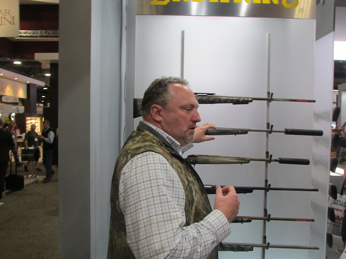 (Tom Wharton | Special to The Tribune) aron Cummings examines some of the rifles Morgan's Browning company was offering to gun dealers at the SHOT Show in Las Vegas on Jan. 23, 2018.
