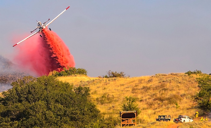 (Steve Griffin  |  The Salt Lake Tribune)  as planes drop fire retardant on a burning ridgeline  above homes in Bountiful Tuesday August 29, 2017.