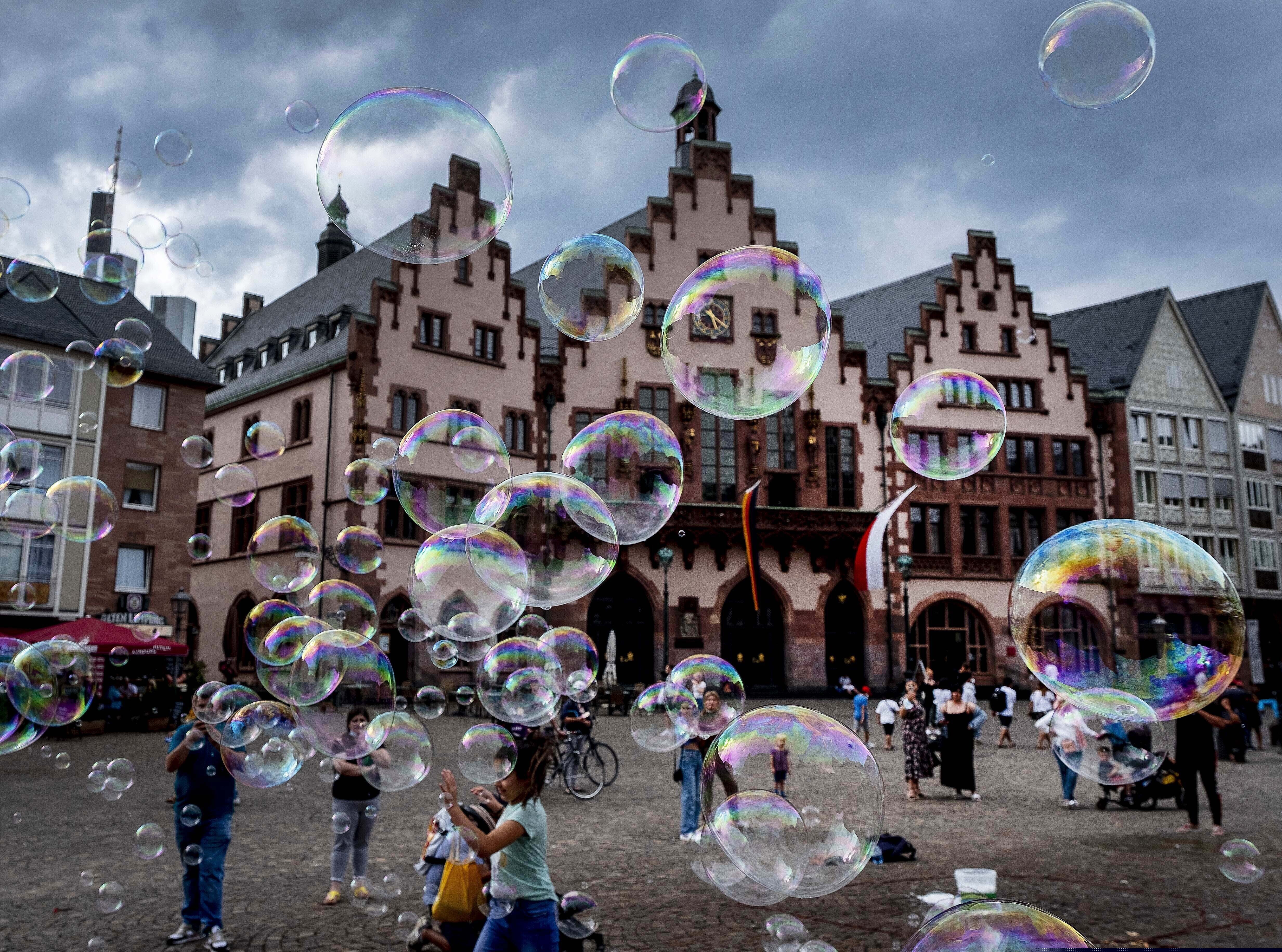 (Michael Probst | AP) A street artist makes bubbles in front of the town hall in Frankfurt, Germany, Monday, Aug. 3, 2020.