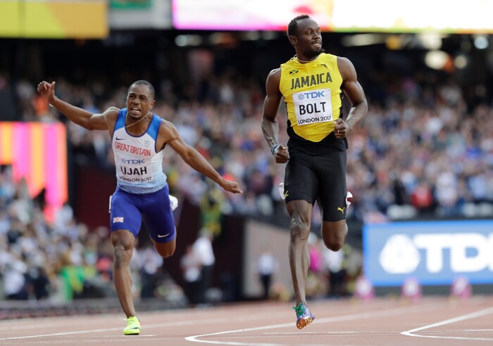 Jamaica's Usain Bolt, right, and Britain's Chijindu Ujah slow down after finishing a Men's 100m semifinal at the World Athletics Championships in London, Saturday, Aug. 5, 2017. (AP Photo/David J. Phillip)