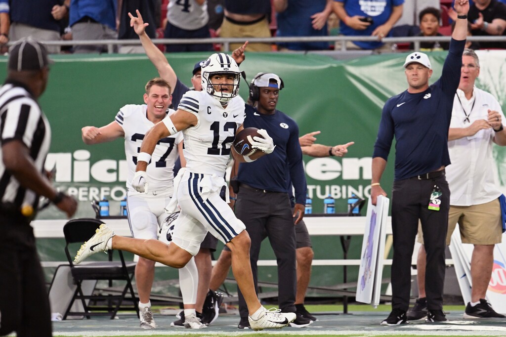 (Jason Behnken | AP) BYU wide receiver Puka Nacua (12) scores on a 75-yard touchdown during the first half of the team's NCAA football game against South Florida on Saturday, Sept. 3, 2022, in Tampa, Fla.