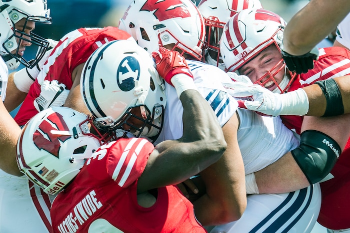 (Chris Detrick  |  The Salt Lake Tribune)  Wisconsin Badgers linebacker Leon Jacobs (32) Wisconsin Badgers defensive end Alec James (57) Wisconsin Badgers linebacker Chris Orr (54) and Wisconsin Badgers defensive end Conor Sheehy (94) tackle Brigham Young Cougars running back Ula Tolutau (5) during the game at LaVell Edwards Stadium Saturday Saturday, September 16, 2017. Wisconsin Badgers are leading Brigham Young Cougars 24-6 at halftime.