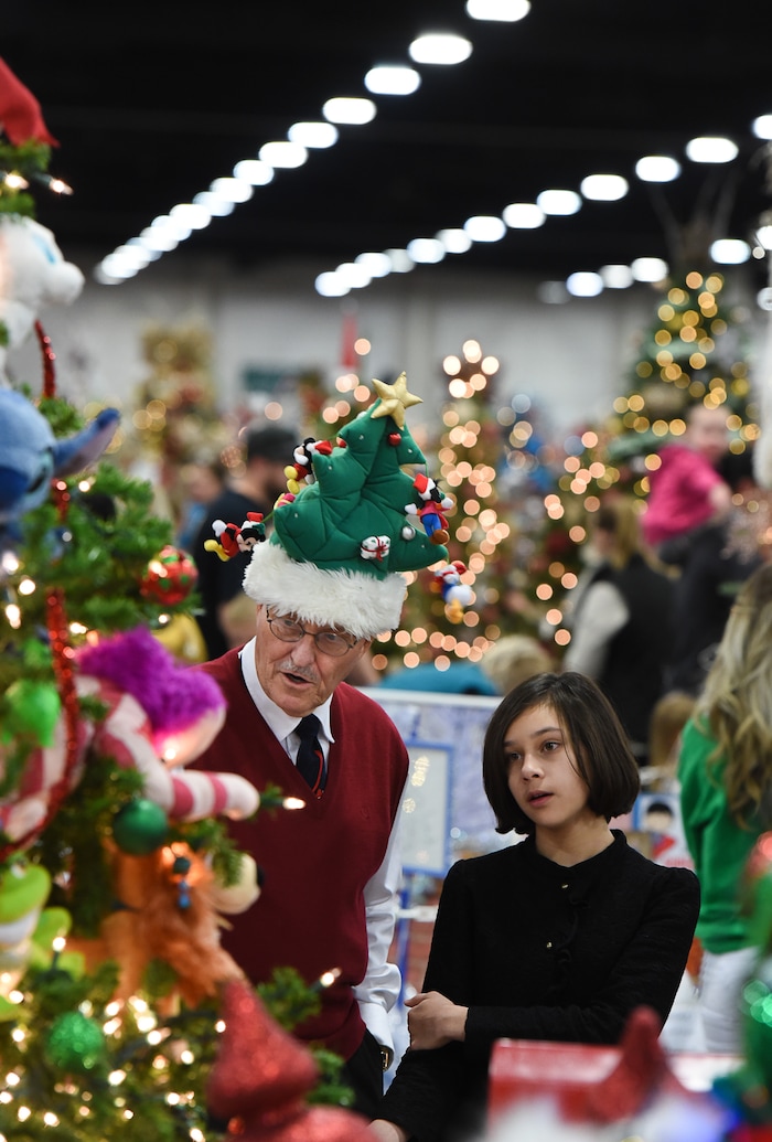 (Francisco Kjolseth  |  The Salt Lake Tribune)  John Watkins of Clearfield gets into the spirit of the Festival of Trees at the South Towne Exposition Center in Sandy on Friday, Dec. 1, 2017. "It's on my head and it's for sale," exclaimed Watkins as he walked the isles with his granddaughter Emma Bargar, 11. The annual festival which runs through Saturday raises money for children at Primary Children's Hospital.