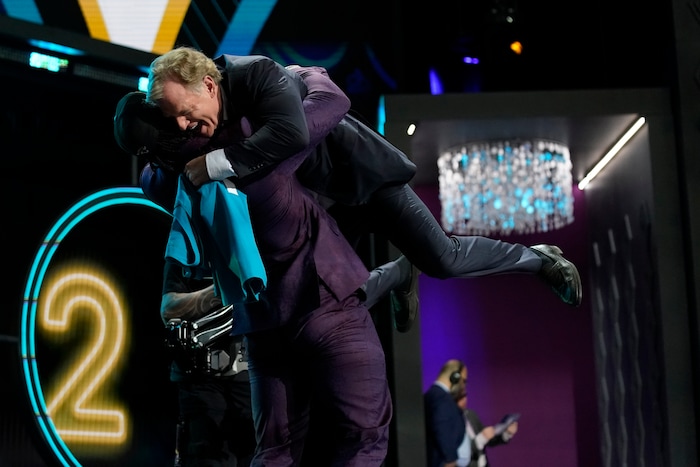 Utah linebacker Devin Lloyd lifts NFL Commissioner Roger Goodell after being chosen by the Jacksonville Jaguars with the 27th pick of the NFL football draft Thursday, April 28, 2022, in Las Vegas. (AP Photo/John Locher)