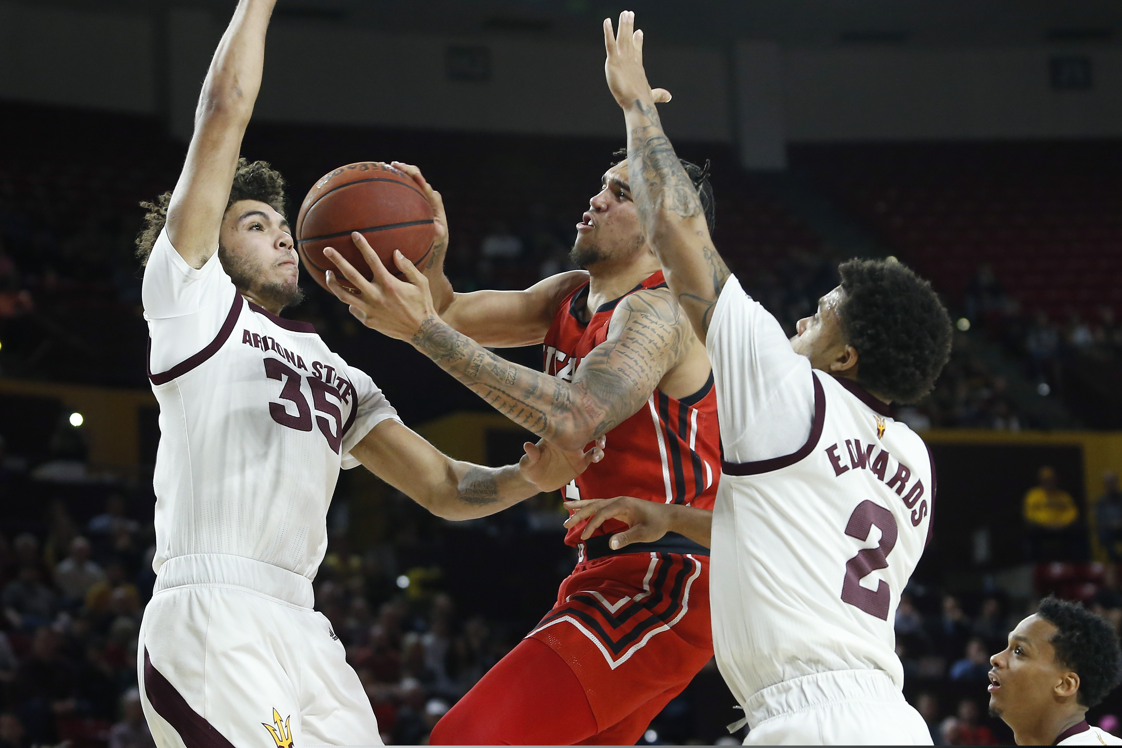 (Ralph Freso | AP) Utah forward Timmy Allen, center, drives to the basket between Arizona State's Taeshon Cherry (35) and Rob Edwards (2) during the first half of an NCAA college basketball game Saturday, Jan. 18, 2020, in Tempe, Ariz.