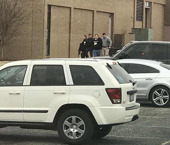 Police escort a person, second from right, out of the Marshall County High School after shooting there, Tuesday, Jan 23, 2018, in Benton, Ky. One person was killed and others were wounded Tuesday morning in a shooting at the rural Kentucky high school, authorities said. (Dominico Caporali via AP)