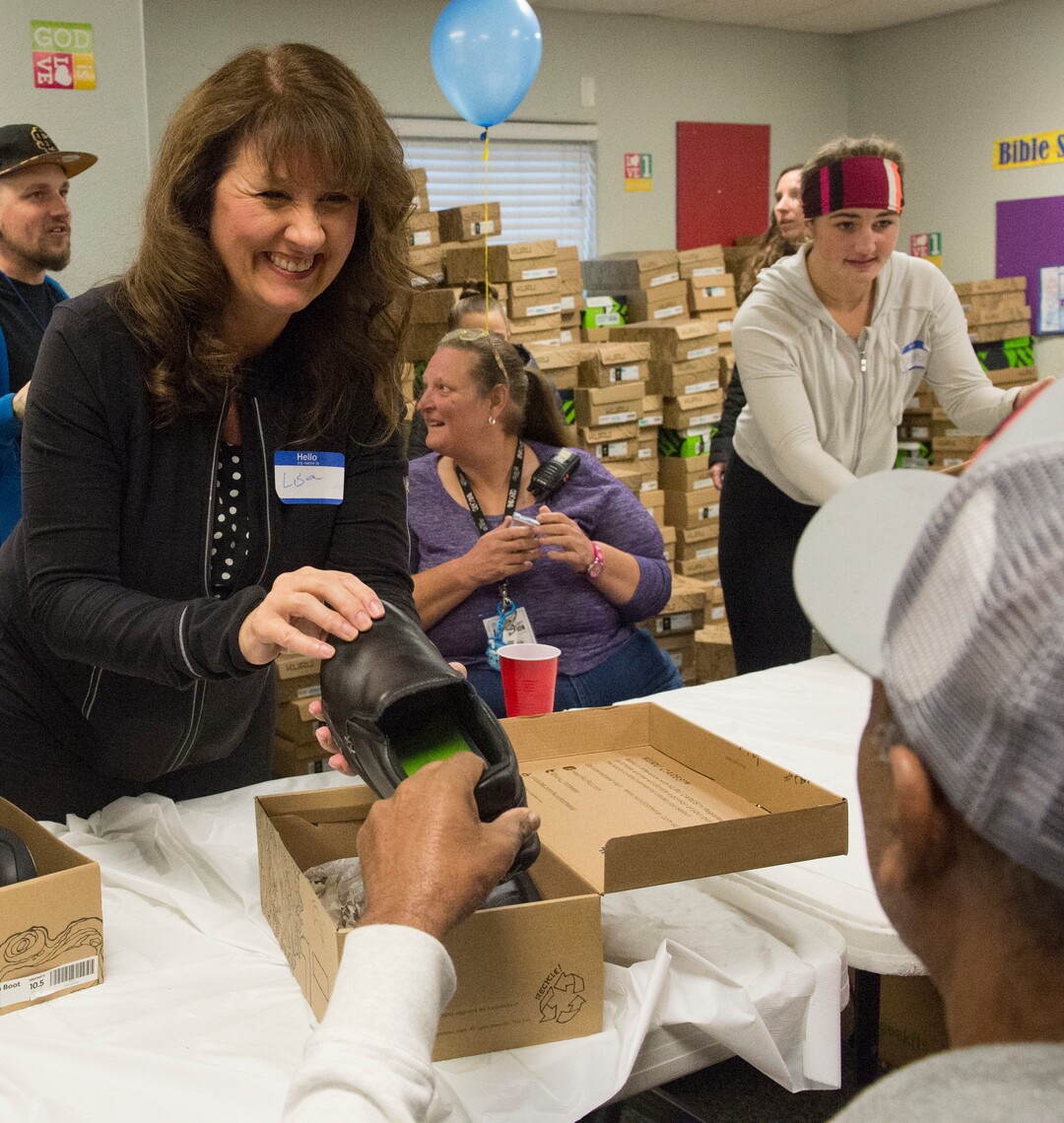 (Rick Egan  |  The Salt Lake Tribune)     Volunteer Lisa Howlett, hands out shoes, at the 25th annual Thanksgiving Dinner for the hungry and homeless, at the Christian Life Center, on Redwood Road in Salt Lake City, Wednesday, Nov. 21, 2018.