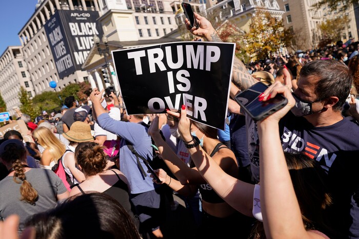 People gathered in Black Lives Matter Plaza react to the presidential race being called by CNN in Democratic presidential candidate Joe Biden's favor over Pres. Donald Trump to become the 46th president of the United States, Saturday, Nov. 7, 2020, in Washington. His victory came after more than three days of uncertainty as election officials sorted through a surge of mail-in votes that delayed the processing of some ballots. (AP Photo/Jacquelyn Martin)