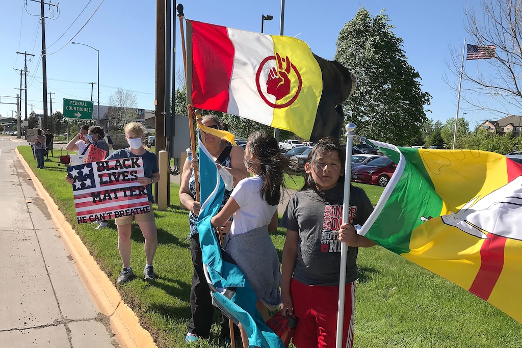 (Karl Puckett | The Great Falls Tribune via AP) Debbie McShane stands with her children, Kendalyn and Sky Running Enemy in Great Falls, Mont., at a May 30, 2020 rally for George Floyd, who died May 25 after being restrained by Minneapolis. Tribal members in Montana are wondering if they will be included in the dialogue about changing race relations.