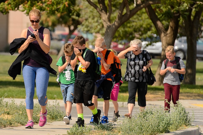 (Trent Nelson | The Salt Lake Tribune)  Children are evacuated from South Weber Elementary School as a fire burns at the mouth of Weber Canyon, Tuesday September 5, 2017.