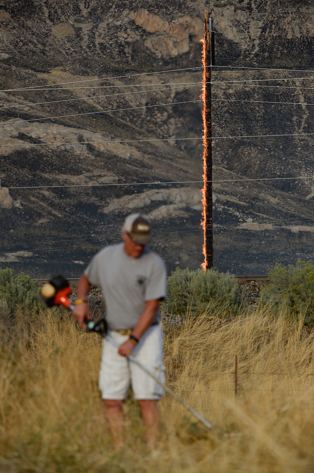 (Francisco Kjolseth  |  The Salt Lake Tribune)  The community comes together to cut down tall brush as crews battle a grass fire in Tooele county being dubbed the Green Ravine fire as it burns on Tuesday, Sept. 3, 2019.