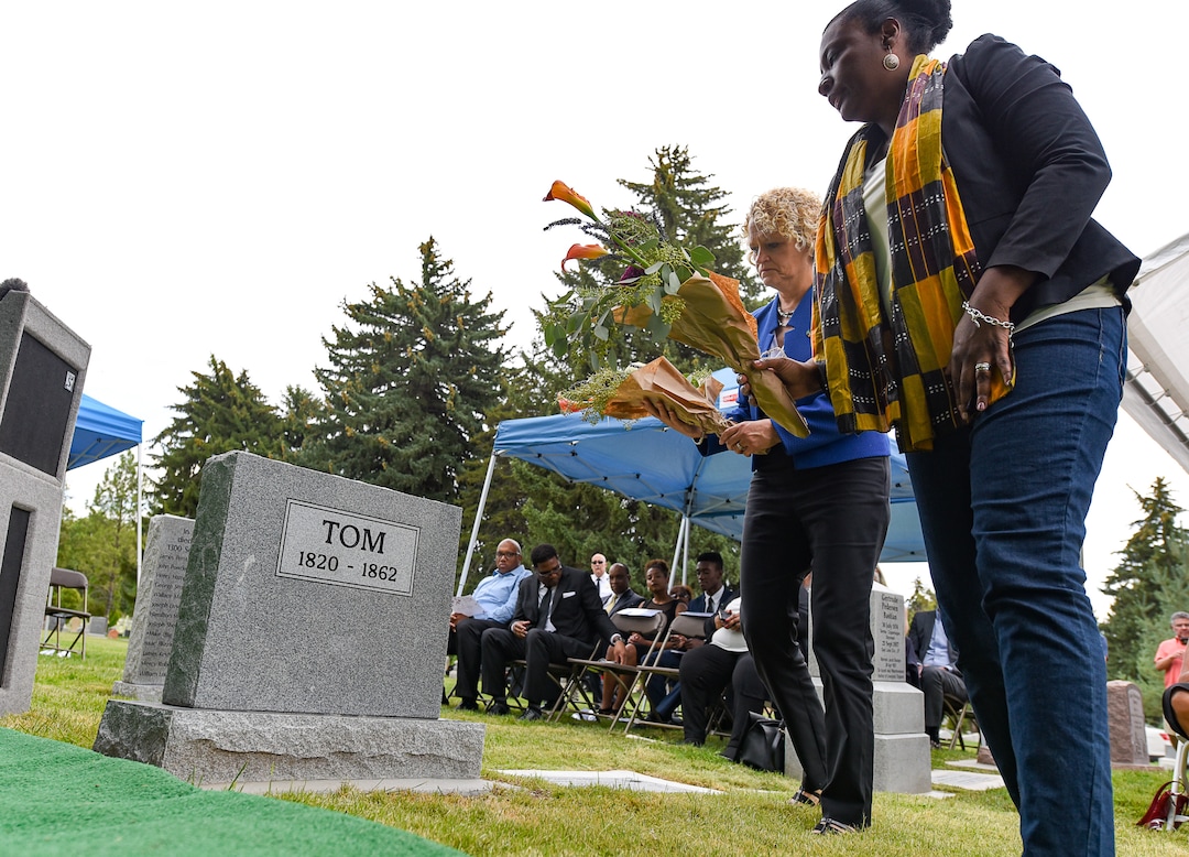(Francisco Kjolseth  |  The Salt Lake Tribune)  Salt Lake City Mayor Jackie Biskupski, background, and Representative Sandra Hollins, D-Salt Lake, lay flowers at the grave of Tom, an enslaved Black pioneer who was buried in the Salt Lake City Cemetery in 1862. TomÕs grave marker was dedicate at the Salt Lake City Cemetery in Salt Lake City on Thursday, Aug. 22, 2019.