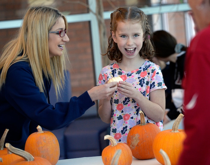 (Al Hartmann | The Salt Lake Tribune)
Armanda Mercado with Utah Department of Corrections helps Aubrey Nelson chose a favorite pumpkin at Kauri Sue Hamilton School in Riverton. She liked the miniature white pumpkin among the many that was grown by inmates in the Green Thumb Nursery program at Utah State Prison. Thousands of pumpkins were harvested this season for donation to local children with significant disabilities.