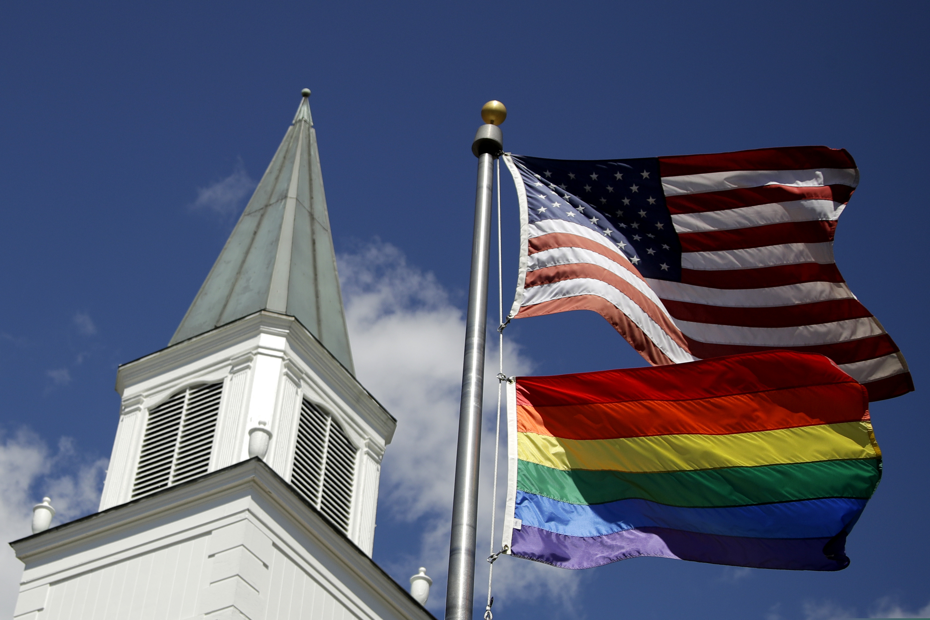 (Charlie Riedel | AP file photo)  A gay pride rainbow flag flies along with the U.S. flag in front of a church in Prairie Village, Kan., on April 19, 2019.