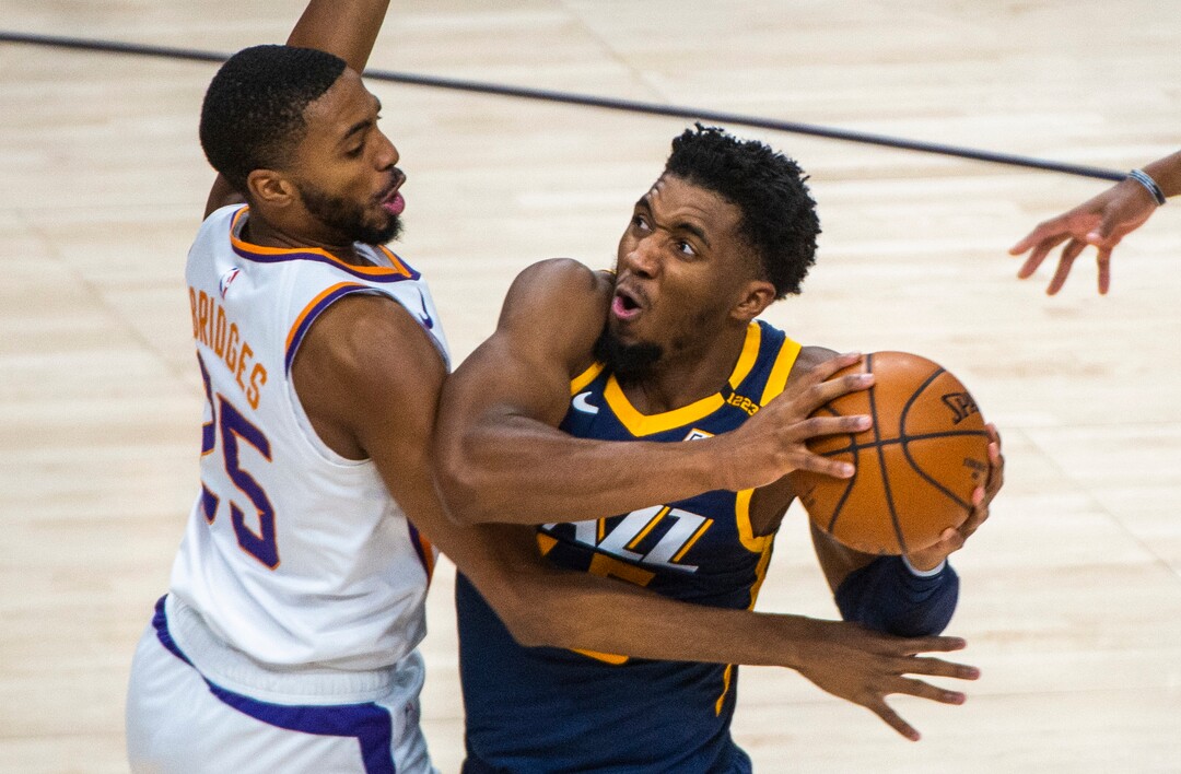 (Rick Egan | The Salt Lake Tribune) Utah Jazz guard Donovan Mitchell (45) takes the ball to the hoop, as Phoenix Suns forward Mikal Bridges (25) defends, in NBA action between the Utah Jazz and the Phoenix Suns, on Thursday, Dec. 31, 2020.