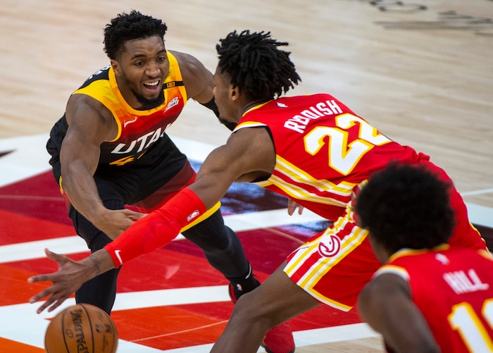(Rick Egan | The Salt Lake Tribune) Utah Jazz guard Donovan Mitchell (45) tosses a pass under the arms of Atlanta Hawks guard Cam Reddish (22), in NBA action between the Utah Jazz and the Atlanta Hawks at Vivint Arena, on Friday, Jan. 15, 2021. Mitchell scored 20 points in the first half.