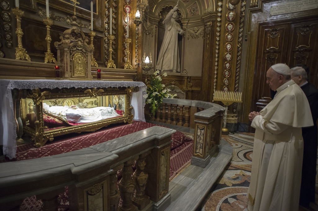 (L' Osservatore Romano  |  Pool Photo via AP)  In this pool photo taken Sunday, June 21, 2015, and made available Monday, June 22, Pope Francis prays in front of the tomb of St John Bosco in the Santa Maria Ausiliatrice Basilica of Turin, northern Italy. Pope Francis earlier prayed in front of the Holy Shroud, the 14 foot-long linen revered by some as the burial cloth of Jesus, on display at the Cathedral of Turin.