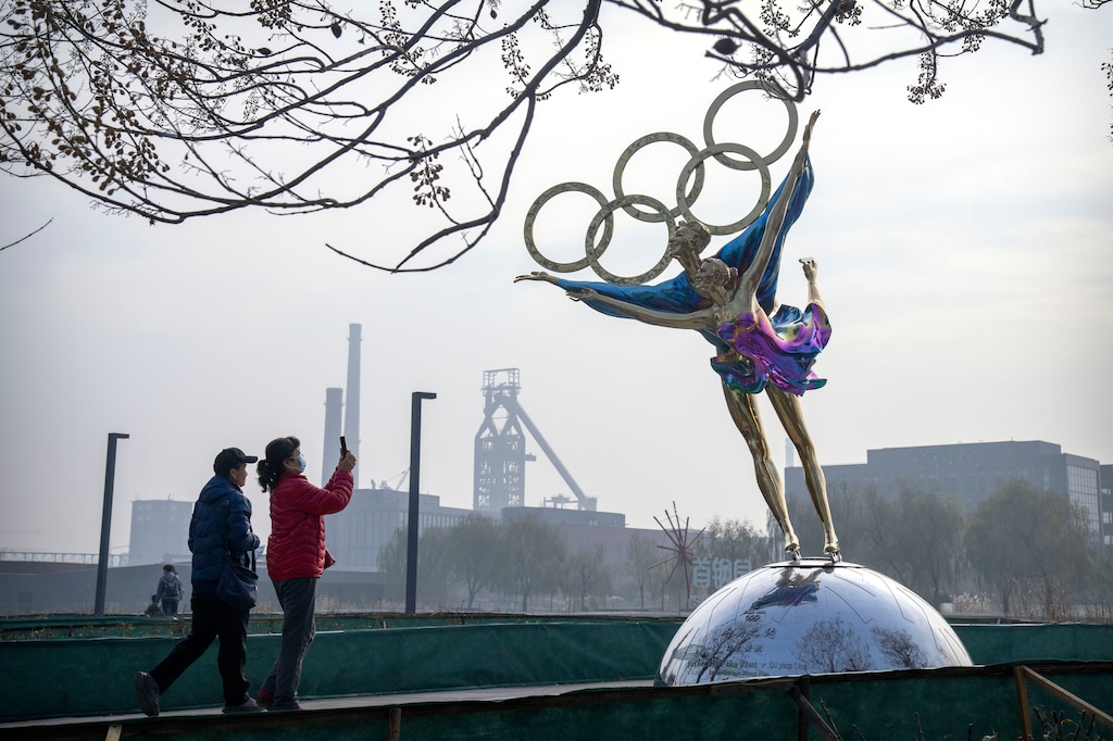 (Mark Schiefelbein | AP) Visitors take photos of a statue of figure skaters with the Olympic rings at a park near the headquarters of the Beijing Organizing Committee for the Olympic Games (BOCOG) in Beijing, Thursday, Nov. 18, 2021. President Joe Biden said this week that his administration is considering a diplomatic boycott of the winter Olympics.