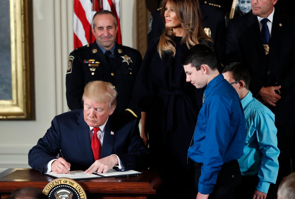President Donald Trump signs a  presidential memorandum declaring the opioid crisis a public health emergency in the East Room of the White House, Thursday, Oct. 26, 2017, in Washington. (AP Photo/Pablo Martinez Monsivais)