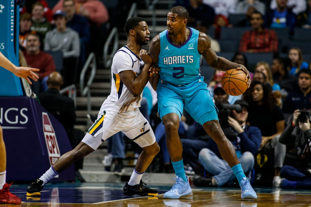 Charlotte Hornets forward Marvin Williams, right, drives into Utah Jazz guard Emmanuel Mudiay in the first half of an NBA basketball game in Charlotte, N.C., Saturday, Dec. 21, 2019. (AP Photo/Nell Redmond)