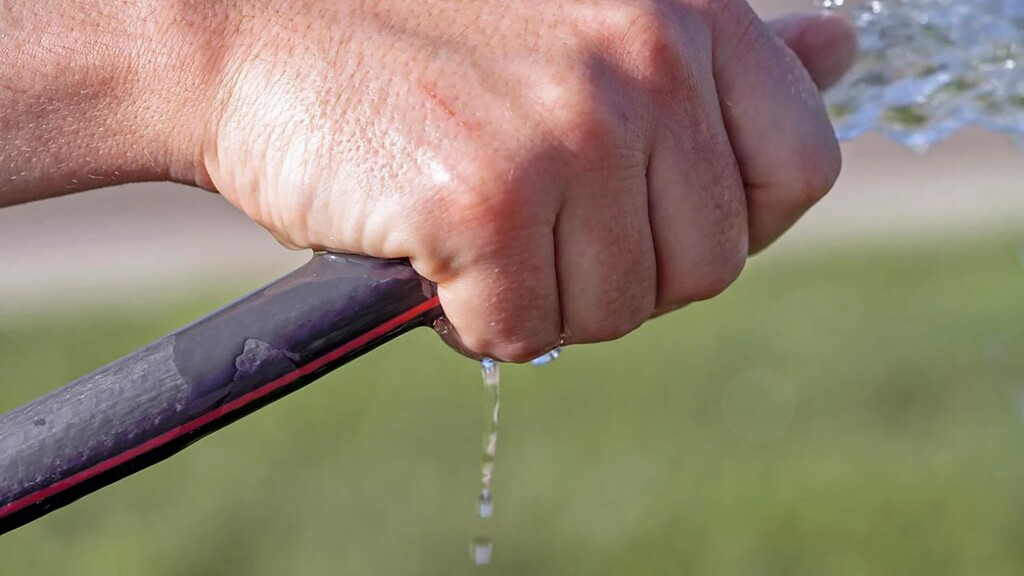 (Alysha Lundren | St. George News) A Cedar City resident grips a dripping lawn hose. Cedar City officials urge residents to conserve water as aquifers drop amid drought.