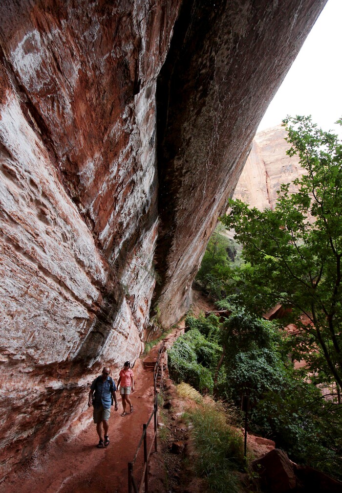 Hikers walk the Emerald Pools Trails Friday, Sept., 4, 2009, in Zion National Park, Utah. Both Zion and Bryce were formed millions of years ago when the Earth's crust violently heaved, leaving behind stunning, unique arrays of rock formations. (AP Photo/Ross D. Franklin)