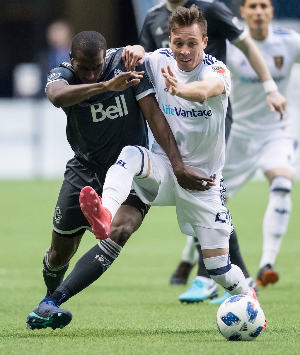 Vancouver Whitecaps' Ali Ghazal, left, and Real Salt Lake's Corey Baird vie for the ball during the first half of an MLS soccer match Friday, April 27, 2018, in Vancouver, British Columbia. (Darry Dyck/The Canadian Press via AP)
