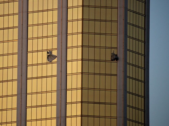 Drapes billow out of broken windows at the Mandalay Bay resort and casino Monday, Oct. 2, 2017, on the Las Vegas Strip following a mass shooting at a music festival in Las Vegas. Authorities say Stephen Craig Paddock broke the windows and began firing with a cache of weapons, killing dozens and injuring hundreds. (AP Photo/John Locher)