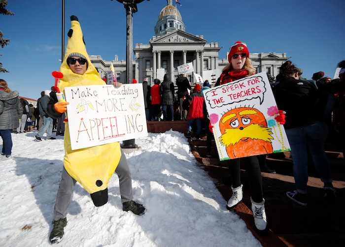 Hung Huynh, left, a teacher at Castro Elementary, joins his colleagues during a strike rally on the west steps of the state Capitol, Monday, Feb. 11, 2019, in Denver. The strike is the first for teachers in Denver since 1994 and centers on base pay. (AP Photo/David Zalubowski)