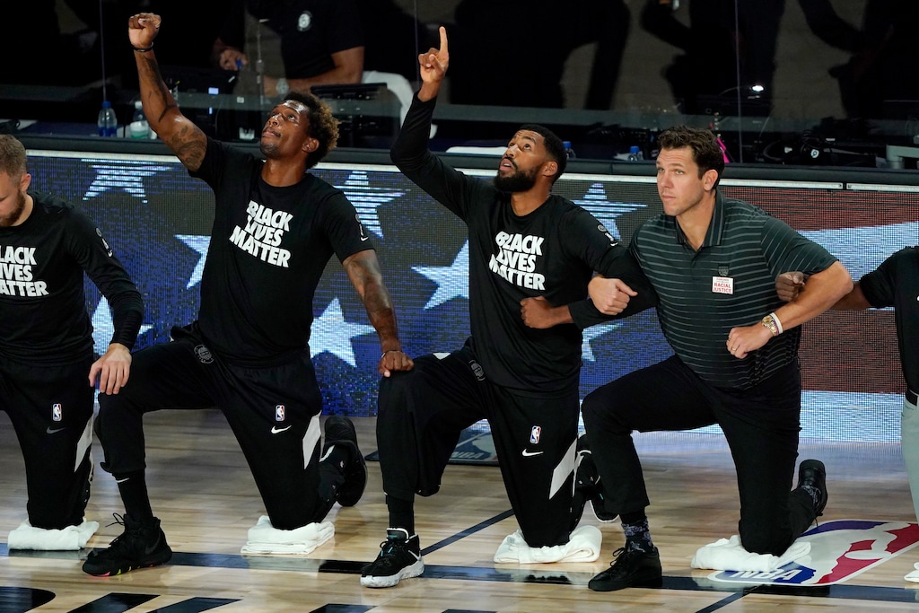 (Ashley Landis | AP) Brooklyn Nets' Lance Thomas, left, and Garrett Temple, center, gesture while taking a knee with Sacramento Kings' head coach Luke Walton in honor of the Black Lives Matter movement during the playing of the national anthem prior to an NBA basketball game against the Brooklyn Nets Friday, Aug. 7, 2020 in Lake Buena Vista, Fla.