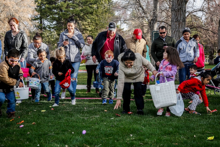 (Nicole Boliaux | For The Tribune) Children and their families run to grab Easter eggs during the annual Easter egg hunt put on by A Kid's Place Dentistry in Liberty Park in Salt Lake City on Saturday, March 31, 2018.