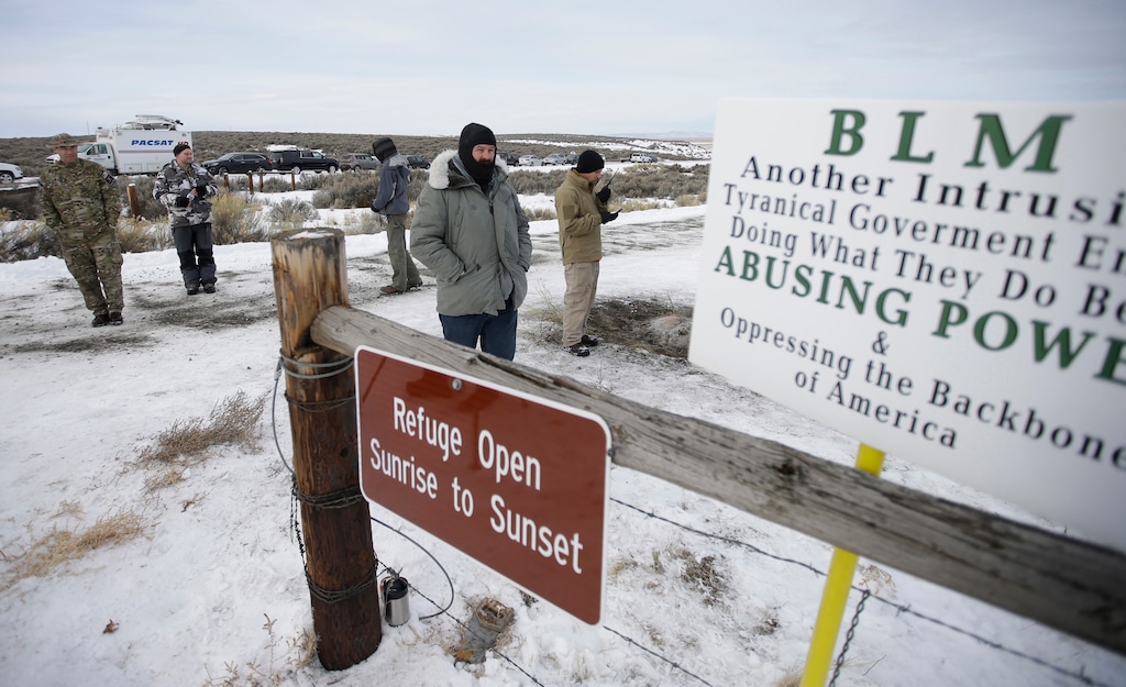 (Rick Bowmer | AP file photo) Members of the group occupying the Malheur National Wildlife Refuge headquarters stand guard near Burns, Ore., on Jan. 4, 2016. A new government report says there have been more than 360 assaults or threats against federal land managers in recent years.