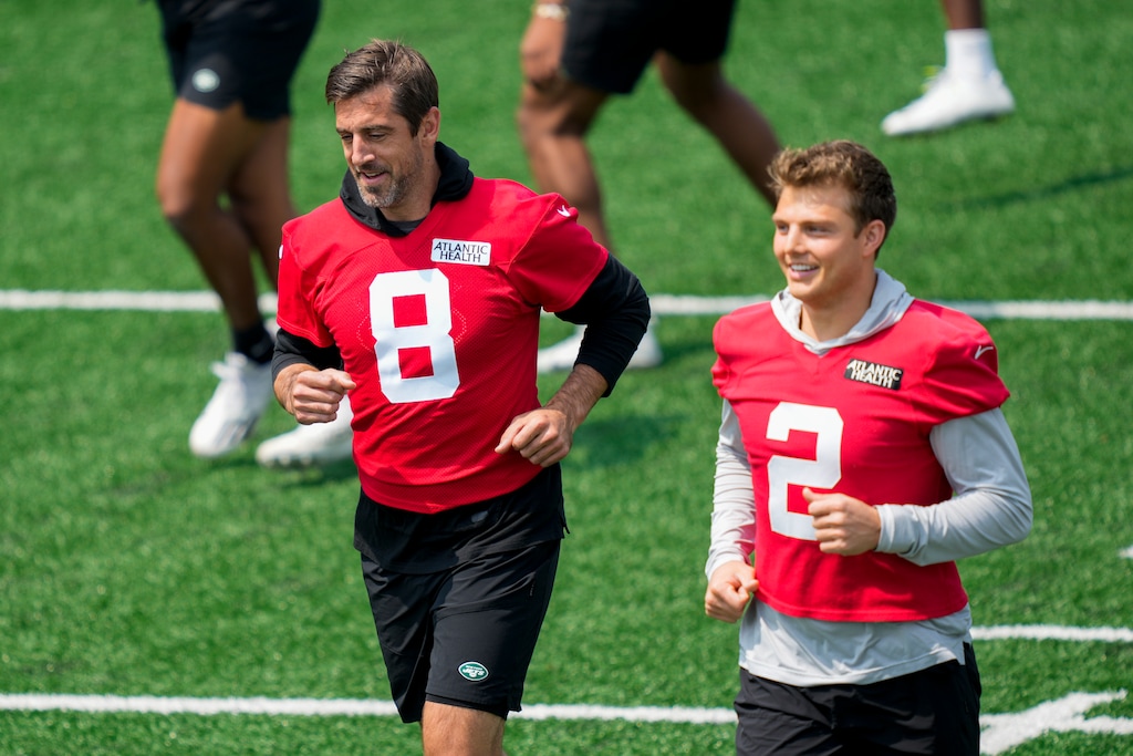 (John Minchillo | AP) New York Jets quarterback Aaron Rodgers (8) performs stretching drills with quarterback Zach Wilson (2) at the NFL football team's practice facility in Florham Park, N.J.
